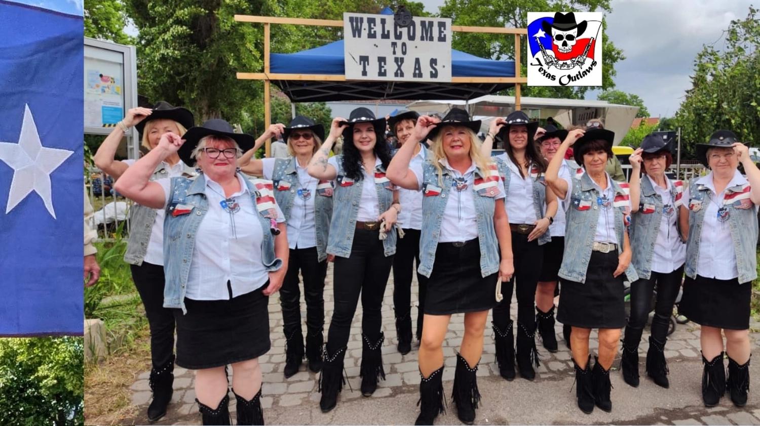 Texas Outlaws -  Line dance club - Tänzer in Cowboyhüten, Jeanswesten und Stiefeln posieren unter einem „Welcome to Texas“-Schild.