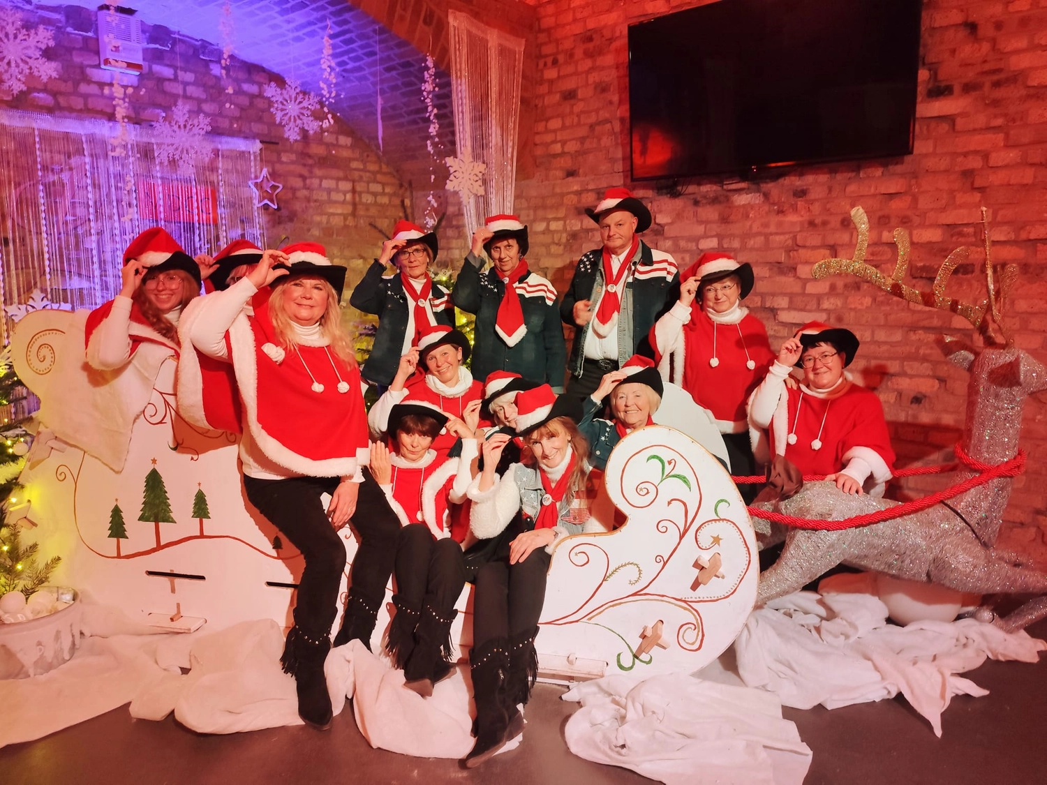 Texas Outlaws - Line dance club - Eine Tanzgruppe in aufeinander abgestimmten rot-weißen Festtagskostümen während einer Weihnachtsaufführung.